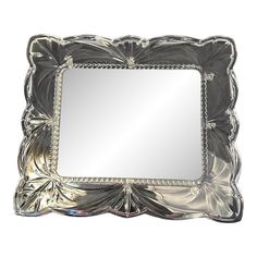 a silver mirror sitting on top of a white wall