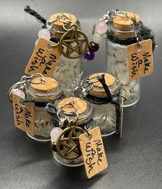 four glass jars filled with different types of items and labeled with words on the tags