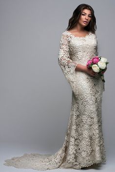 a woman in a white wedding dress holding a bouquet of flowers and posing for the camera