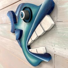 a close up of a blue fish head on a wall