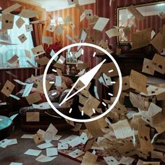 a clock surrounded by many pieces of cardboard and papers flying in the air over a living room