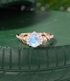 an oval shaped blue topazte and diamond ring sits on a green tire rim