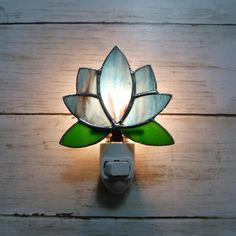 a light that is on the side of a wooden wall with a flower in it