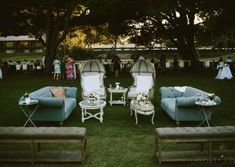 several couches and chairs are set up in the grass for an outdoor wedding reception