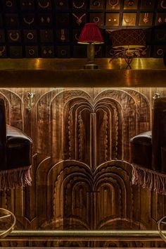 an art deco bar with leather chairs and gold accents