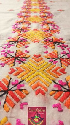 an embroidered table cloth with colorful designs on it