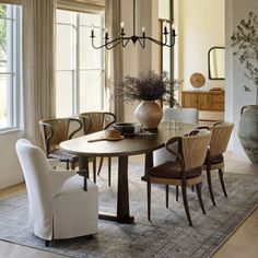 a dining room table with chairs and a chandelier hanging from the ceiling above it