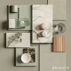 an assortment of art work displayed on a wall with grey walls and white marbles