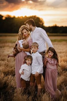 a family poses for a photo in a field