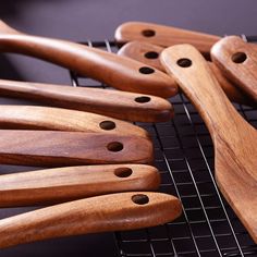 several wooden utensils lined up on a rack