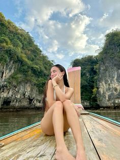 a woman sitting on top of a wooden boat