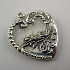 "This antiqued sterling silver, two-sided Acanthus Heart charm features a complex design of Victorian beads, musical clefs, and showy foliage. Made by Brown County Silver. Vintage and in new, never worn condition. Approximately 30 years old. 1 1/8\" high 1\" wide 3.7 grams *Notice this heart does not include a jump ring See more @ https://www.etsy.com/shop/brocosi" Silver Heart Necklace With Heart Beads, Silver Heart Bead Pendant Necklace, Silver Heart Pendant Necklace With Heart Beads, Silver Double Heart Necklace With Heart Beads, Nickel-free Silver Heart Necklace For Memorials, Nickel-free Silver Heart Necklace For Memorial, Silver Nickel-free Heart Necklace For Memorial, Silver Heart-shaped Etched Jewelry, Etched Heart Silver Jewelry