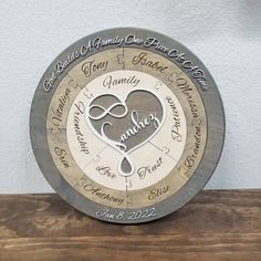 a personalized clock with the names of two people and hearts on it, sitting on top of a wooden table