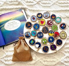 an open book and some cookies on a plate with a drawstring bag next to it