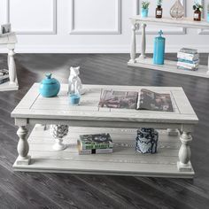 a white coffee table sitting on top of a hard wood floor next to a book shelf