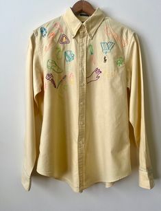 Ralph Lauren- cotton/button down/light yellow/SIZE  14 classic fit reads the label  please note measurements shirt measures SIZE S-M/embroidered intervention by me, Lisa V with neon thread/flash icons/one of a kind/no holes, no stains/near perfect Across the Shoulder - 17" Pit to Pit - 21" Neck - 16" Sleeve - 24.5" Length of Garment - 27" Yellow Embroidered Cotton Shirt, Embroidered Denim Shirt, Embroidered Shirt Dress, Down Light, Embroidered Denim, Ralph Lauren Shirt, Light Yellow, Denim Shirt, Dress Shirt