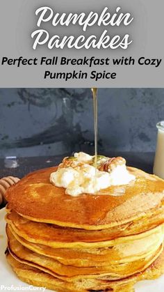 stack of pumpkin pancakes with syrup and whipped cream on top