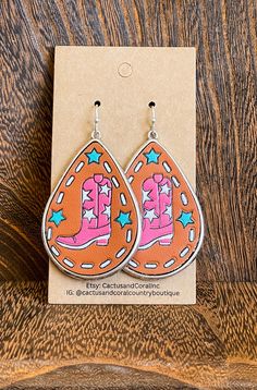 Pink leather cowgirl boot earrings are the perfect accessory for any country concert outfit. These earrings add a touch of western flair to your look, making them a must-have for any western concert outfit. adorned with little white and turquoise stars. Pink western jewelry is a great way to add a pop of color to your concert outfit. These earrings are unique and eye-catching, perfect for standing out in the crowd #CowgirlBootEarrings #CountryConcertOutfit #WesternJewelry Western Concert Outfit, Pahrump Nevada, Boot Earrings, Western Bachelorette, Western Rings, Western Bracelets, Leather Cowgirl Boots, Western Wear Outfits