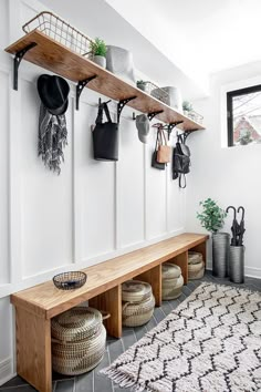 an entryway with pots and pans hanging on the wall next to a bench