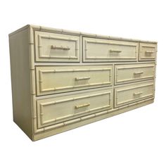 a white dresser with bamboo handles on it's sides and drawers in the middle