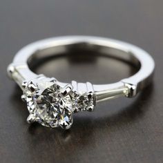 a three stone diamond engagement ring on a table