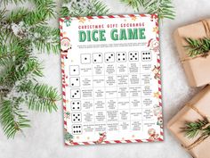 a christmas gift exchange dice game is shown with presents and pine branches on the table