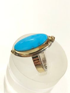 "This modern Natural Sleeping Beauty Turquoise ring was fabricated in my studio using 18k Gold, and Sterling Silver. This gorgeous all natural Sleeping Beauty Turquoise Blue cabochon is worthy to be set in gold. The cabochon is set with a 1/8\" tall 18k bezel. The sterling silver rectangle ring band is adorned with a 1/8\" wide 30 gauge strip of 18k Gold. The bezel, 18k Gold Beads, and band are soldered on a 24 gauge Sterling Silver back plate. The Ring is nearly 1\" ( 23.2 mm ) long x 7/16\" (1 Silversmith Jewellery, Arizona Turquoise, Sterling Silver Rings Bands, Royston Turquoise, Sleeping Beauty Turquoise, Blue Gems, Silver Band Ring, Hand Made Jewelry, Oval Cabochon