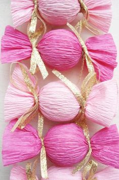 pink balls with gold ribbons and bows on them