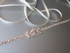 "This sparkly skinny bridal belt is made with Swarovski crystals beaded on 3/8\" wide satin ribbon. The crystal part of the bealt measures 12 1/2\" long and 1 1/8\" wide in the center. The entire sash measures 150\" long. Available in gold, silver or rose gold finish and with satin or grosgrain ribbon. For the photo of the satin ribbon color options, please take a look here: https://www.etsy.com/listing/248390980/rose-gold-bridal-crystal-belt-crystal?ref=shop_home_active_22 For the photo of the Adjustable Bridal Belt With Sashes For Party, Adjustable Sashes Bridal Belt For Party, Adjustable Bridesmaid Bridal Belt With Sashes, Adjustable Bridal Belt With Sashes For Bridesmaid, Adjustable Embellished Bridal Belt For Wedding, Elegant Gold Bridal Belt For Bridesmaids, Bridal Hair Veil, Bridal Jewels, Bridal Sash Belt