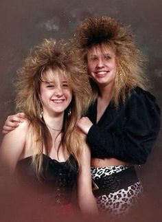 two young women are posing for a photo with their hair blowing in the wind and smiling at the camera