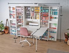 a room with a desk, chair and shelves filled with crafting supplies in it