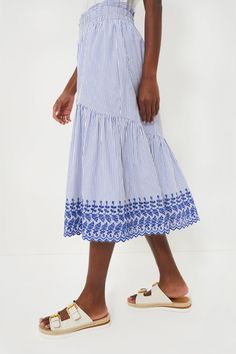 The Blue Stripe Eyelet Cinzia Skirt is an elevated staple that can be easily dress up or down for whatever the occasion calls for. A midi length, featuring a wide embroidered ruffle hem, elastic waistband, and side pockets, this style is equal parts easy and elegant. Pair with a simple white tee and sandals, or a feminine blouse and espadrilles. Elastic ruffle waistband Side pockets Wide ruffle hem Embroidery along hem Midi length Lined Material: 65% Polyester, 35% Cotton (outer), 100% Rayon (li Spring Bottoms With Elastic Waistband And Midi Length, Spring Casual Skirt With Embroidered Hem, Casual Spring Skirt With Embroidered Hem, Summer Ruffle Hem Midi Skirt, Fitted Bottoms With Embroidered Hem For Summer, Casual Midi Skirt With Ruffle Hem, Spring Embroidered Midi Skirt, Spring Embroidered Flowy Skirt, Spring Embroidered Skirted Bottoms