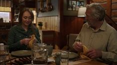 two people sitting at a table eating food