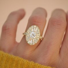 a woman's hand with a yellow sweater holding a diamond ring on her finger