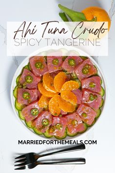 a white plate topped with meat and veggies on top of a table next to utensils