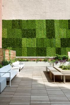 an outdoor seating area with plants on the wall