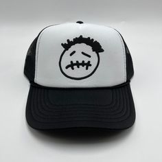 a black and white trucker hat with a face drawn on the front of it