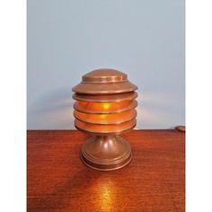 an old fashioned lamp is sitting on a wooden table