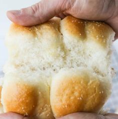 a person holding two pieces of bread in their hands