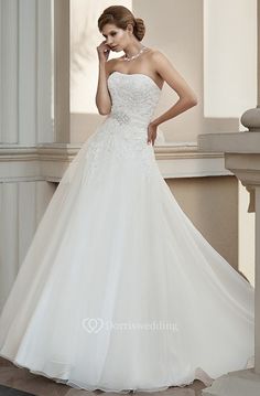 a woman in a white wedding dress posing for the camera with her hand on her face