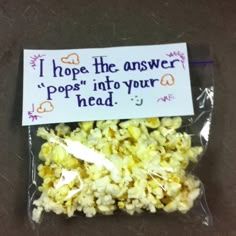 popcorn in a plastic bag with a sign on it that says i hope the answer pops into your head