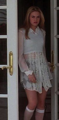 a woman standing in front of a door wearing stockings and knee high socks with her hands on her hips