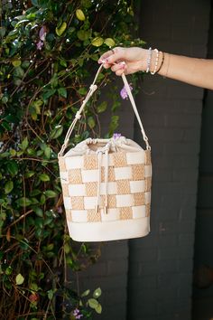 This Boba Checked Bucket Purse combines functionality and style with its versatile design. The weave bucket bag is crafted with faux leather and raffia, giving it a unique and fashionable look. The drawstring closure ensures the safety of your belongings, while the removable adjustable strap allows for convenient carrying options. Stay right on trend with this must have bucket bag. bucket bag weaved fabric faux leather and raffia drawstring closure lined inside adjustable strap removable strap Cream Straw Bag With Braided Handles For Day Out, Casual Bucket Straw Bag With Intrecciato Weave, Straw Bucket Shoulder Bag With Intrecciato Weave, Beige Bucket Bag With Intrecciato Weave For Vacation, Chic Braided Bucket Shoulder Bag, Straw Bucket Bag With Intrecciato Weave, Beige Bucket Bag With Intrecciato Weave, Chic Beige Woven Leather Bucket Bag, Summer Rectangular Bucket Bag With Intrecciato Weave