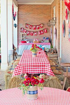 an outdoor birthday party with hay bales and tables covered in red and white checkered tablecloths