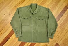 You are looking at a USMC utility shirt circa late 1950's. Nicely faded sateen olive green fabric. Perfectly "worn in" distressed vintage condition with minor imperfections throughout. Overall looks great. Seems to fit a mens size medium. Please refer to measurements to ensure proper fit. Measurements (laying flat): 23" top of collar to bottom in front 21" pit to pit 18.5" pit to end of cuff  22" shoulder seam to end of cuff  19.5" shoulder to shoulder seam at very top Vintage Washed Button-up Top, Vintage Distressed Cotton Shirt, Vintage Faded Pre-washed Tops, Green Washed Vintage Top, Vintage Long Sleeve Faded Tops, Faded Long Sleeve Vintage Tops, Vintage Olive Long Sleeve Tops, Vintage Washed Shirt For Fall, Vintage Pre-washed Fall Shirt