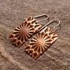 Handcrafted in my studio in Colorado, these lightweight copper earrings are embossed to add texture and are complete with sterling silver ear wire (for those sensitive ears). All of my earrings are made to order...no two earrings are ever completely alike (despite my best efforts!); therefore, your earrings may vary ever-so-slightly from the pictures.   PRODUCTION & SHIPPING  My goal is to have your earrings made and in the mail the following business day. All Teak+Copper packages ship via USPS First Class Mail (3-5 day shipping).  Priority Mail (2-3 day shipping) is available for an additional fee.  Please select your shipping option at checkout.  PACKAGING  If you would like for your earrings to come in a gift box, please select that option when checking out. Etched Copper Jewelry, Pattern Minimalist, 7th Anniversary Gifts, Etched Copper, Earrings Star, Star Burst, Embossed Metal, 7th Anniversary, Fort Collins