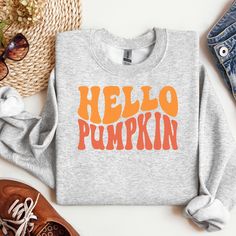 🎃🍁 Say Hello to Cozy Season! 🍁🎃 Embrace the fall vibes with our HELLO PUMPKIN sweatshirt, designed in a fun and wavy retro font that screams nostalgia! This super-soft, snuggle-worthy sweatshirt is your go-to for crisp autumn mornings, pumpkin spice lattes, and everything cozy. 🍂 😁Bring smiles to your world. 🍂 Retro-Inspired Design: The playful font adds a touch of vintage charm to your fall wardrobe! 🎃 Perfect Fall Colors: Pair it with your favorite jeans or leggings for an effortlessly Trendy Fall Sweatshirt With Screen Print, Fall Loungewear Sweatshirt With Screen Print, Trendy Fall Sweatshirt, Trendy Graphic Print Sweatshirt For Fall, Trendy Fall Sweater With Screen Print, Retro Fall Tops With Lettering, Retro Lettering Tops For Fall, Graphic Print Sweatshirt For Fall Loungewear, Trendy Orange Sweatshirt For Fall