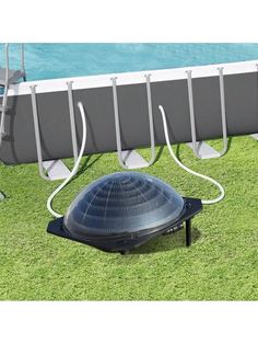 a solar powered pool heater sitting on the grass next to an empty swimming pool