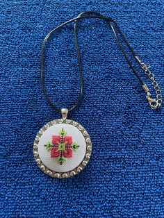 A handmade necklace with a traditional Bulgarian floral pattern. It's made from the hands of a master embroiderer with over 30 years of experience in the creation of tapestries.  Materials used: multi-coloured threads; metal base; polyester cord Size: 45x45mm Price list: (Listed prices include shipping costs) UK - £30 (Royal Mail 1st Class) International - £38.85 (Royal Mail Track & Sign) Handmade Bohemian Multicolor Embroidery Jewelry, Multicolor Bohemian Embroidered Necklace, Bohemian Necklaces With Motifs As Gift, Multicolor Embroidered Bohemian Necklace, Bohemian Necklaces With Motifs For Gift, Multicolor Embroidered Bohemian Necklaces, Folk Style Handmade Jewelry As Gift, Artisan Embroidered Necklaces For Festivals, Handmade Folk Style Jewelry Gift