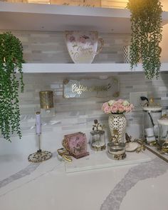 there are many items on the counter in this kitchen that is decorated with flowers and gold